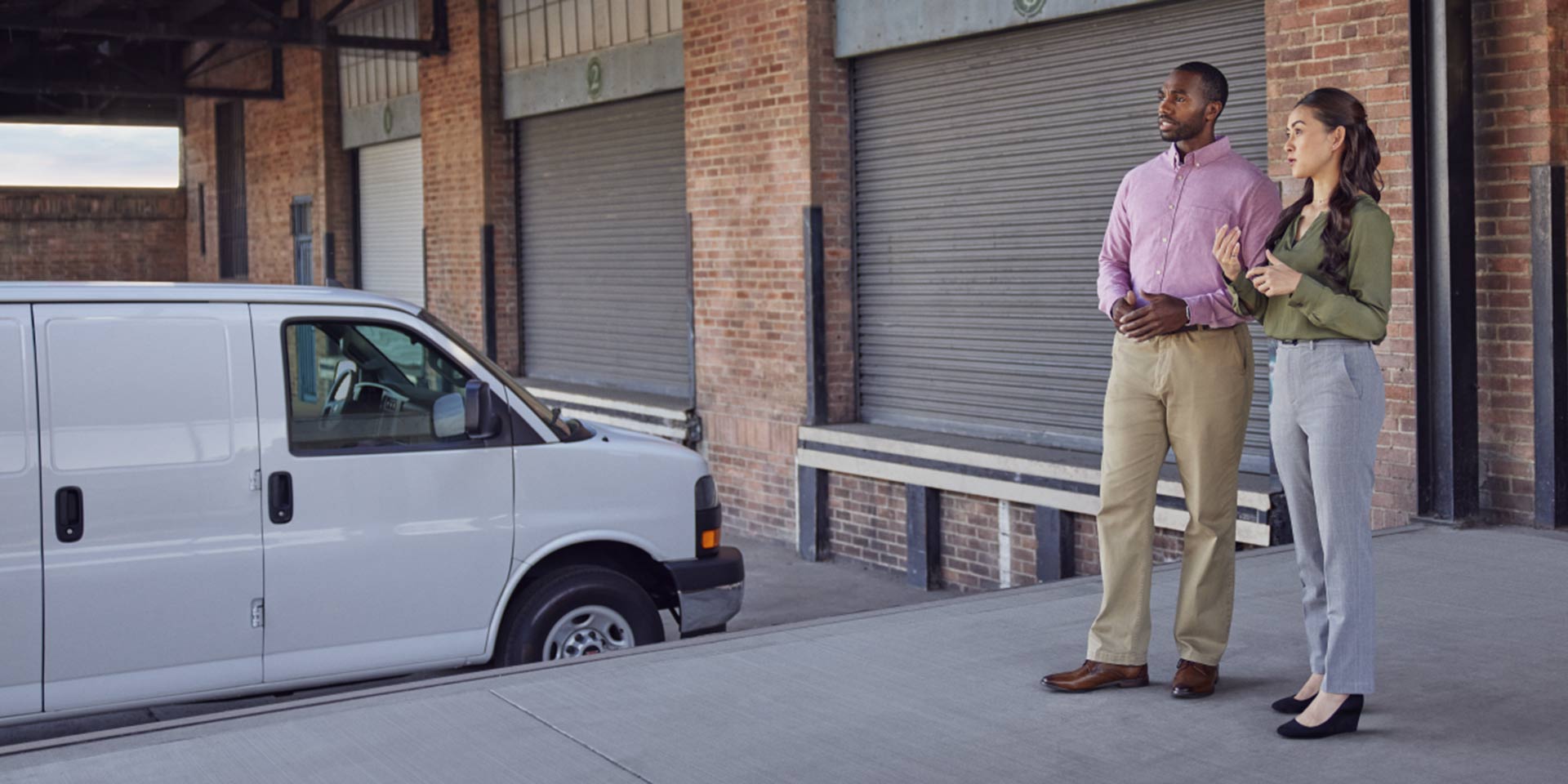 Two Managers Standing Near a Loading Dock Discussing Business