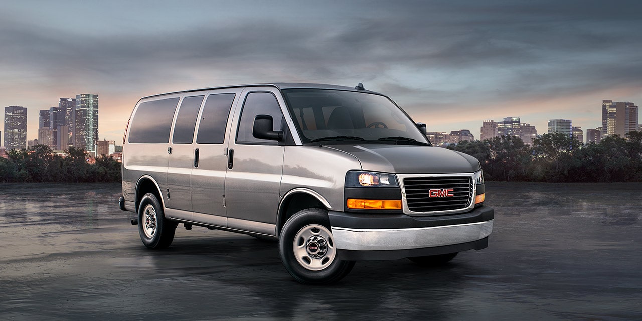 Front Three-Quarters View of the GMC Commercial Savana Passenger Van in a Parking Lot