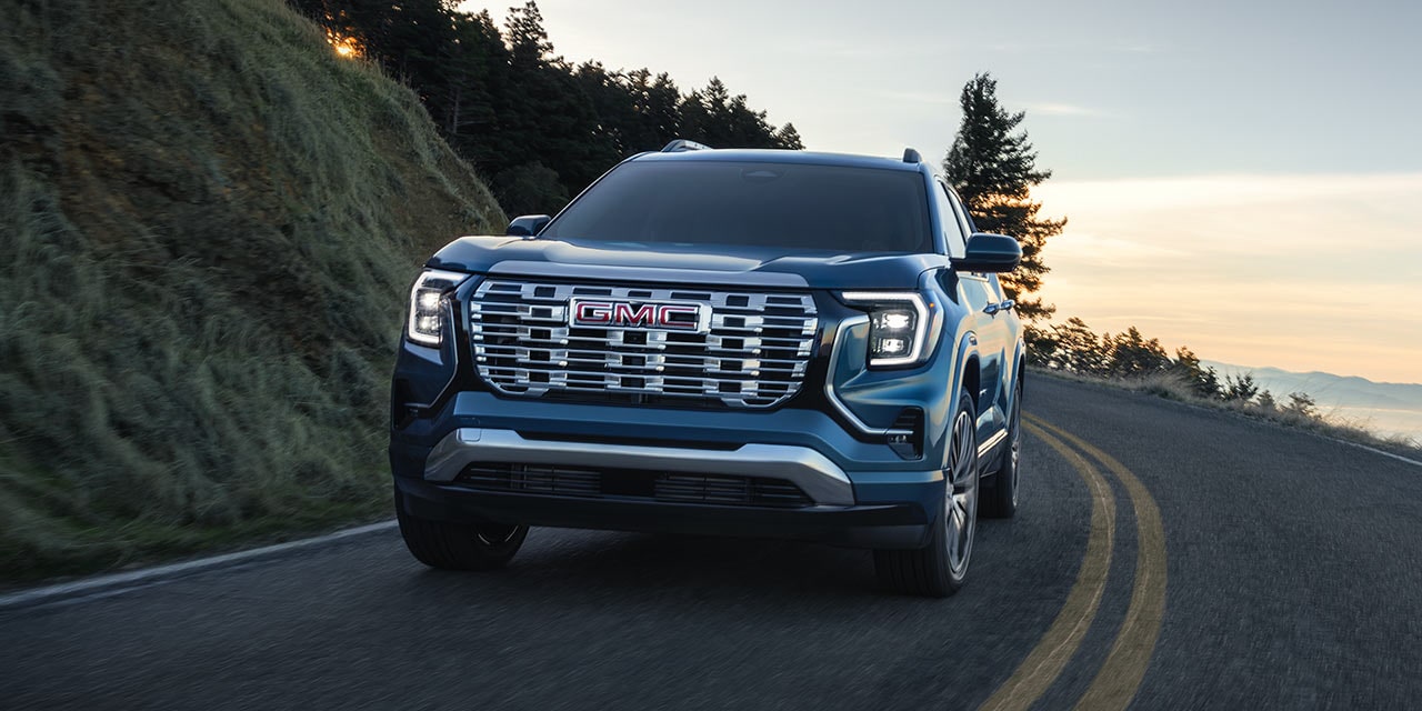 Front Three-Quarters View of a 2026 GMC Terrain Denali Luxury SUV Driving Down the Coast