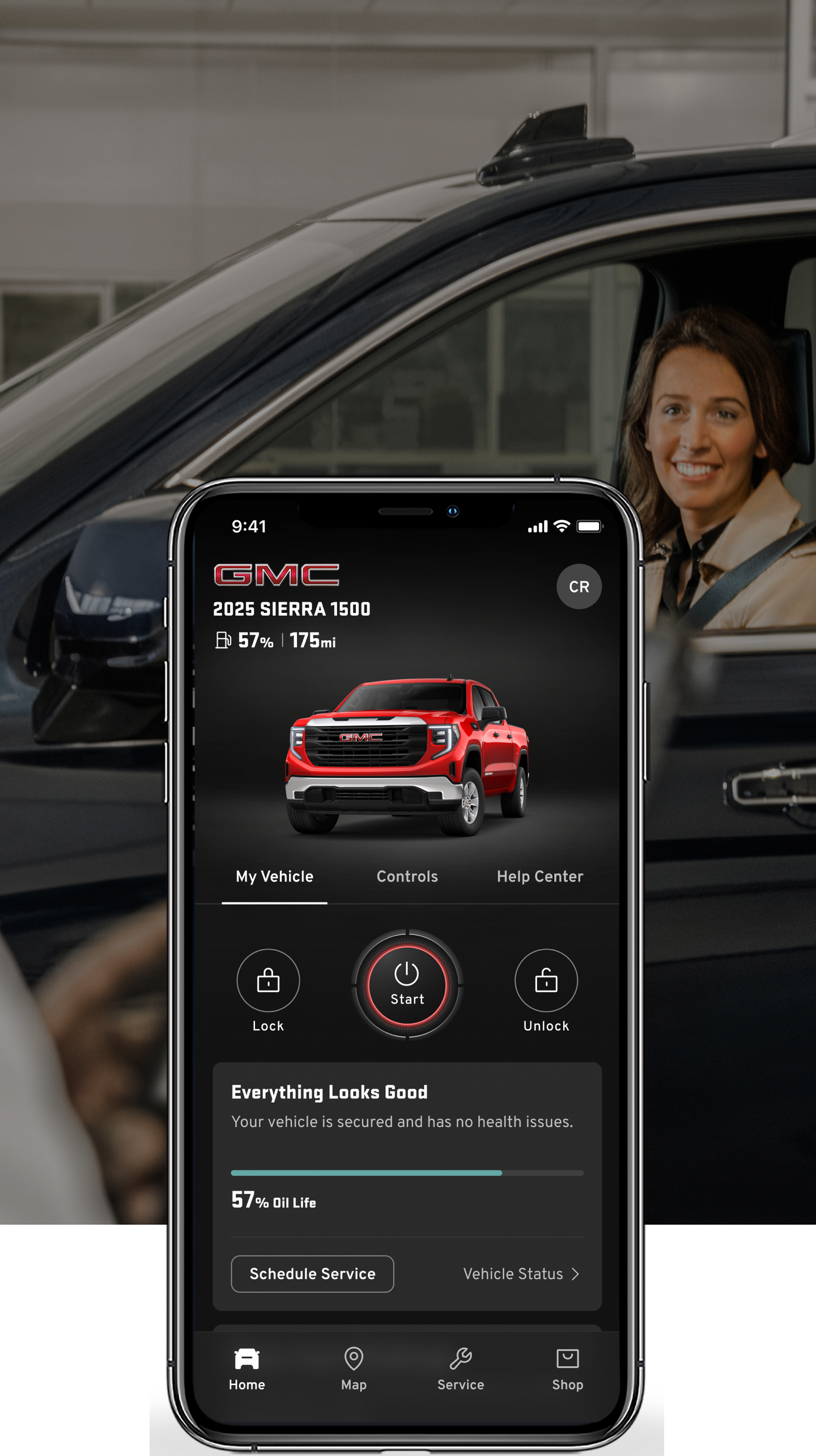 A Woman in a Vehicle with a Phone Displayed on Top of the Image with the myGMC Mobile App.