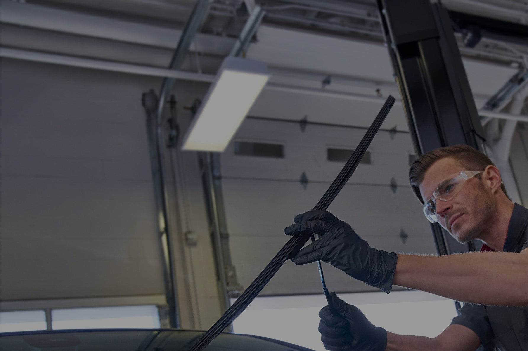 A Technician Changing the Windshield Wiper Blades on a Vehicle.