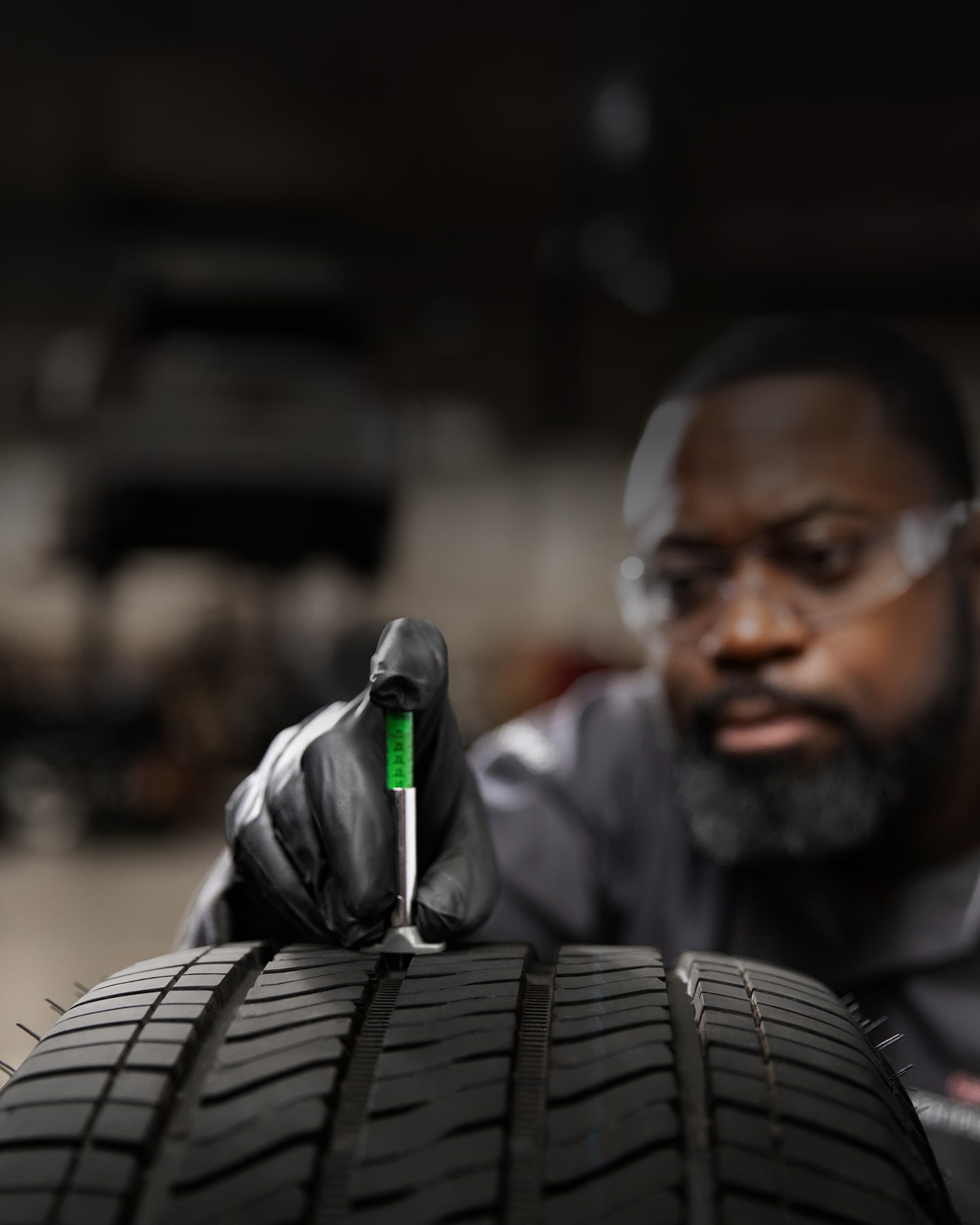 A Technician Measuring the Tire Thread.