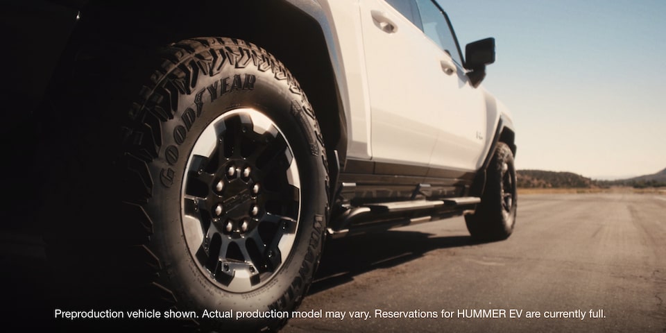 A Low Angle Tires High Shot of a GMC Vehicle Driving Off-Road in the Desert