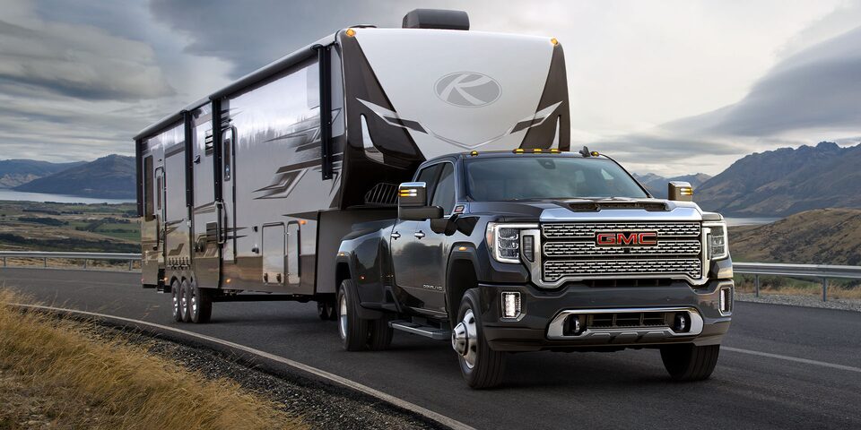 A GMC Truck Towing a Trailer On-Road