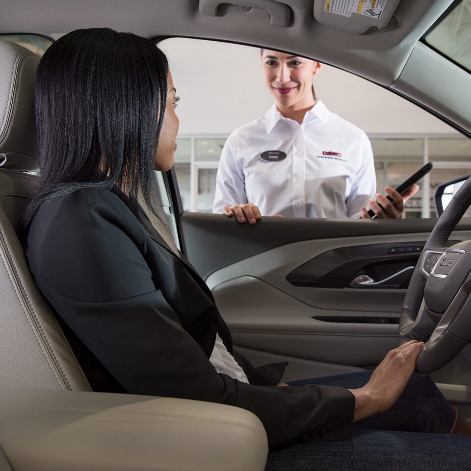 A Woman Using the MyGMC Mobile App at a Dealership