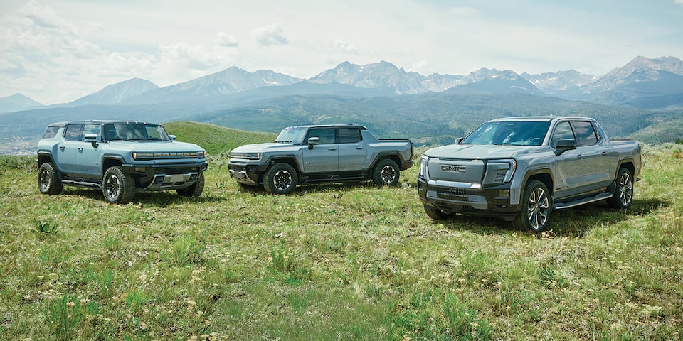 The GMC EV Lineup Parked in a Green Valley