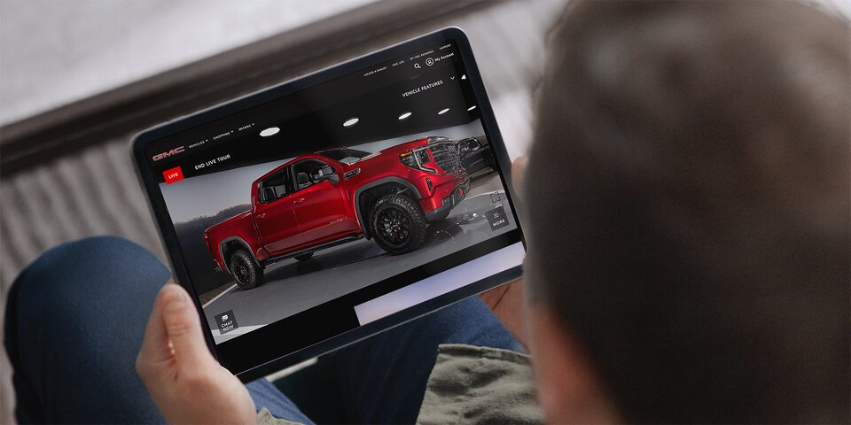 A man holding a Tablet while engaging with GMC Live