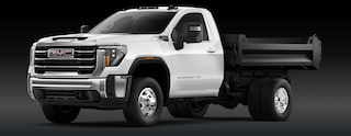 A White GMC Sierra HD Chassis Cab Truck with a Dump Bed Is Shown From the Front Three-Quarters View