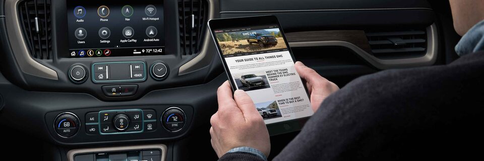 Man looking at GMC "Connected Access" service on tablet