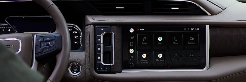 Man in the driver's seat of GMC vehicle pressing the OnStar button