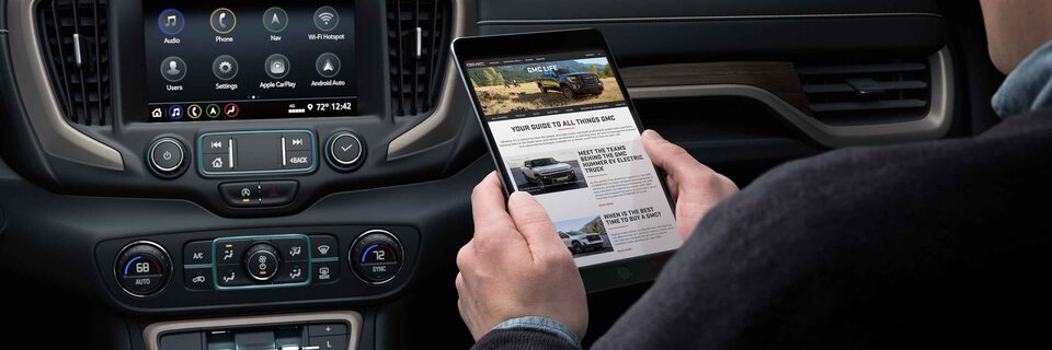 Man using a tablet in a GMC vehicle
