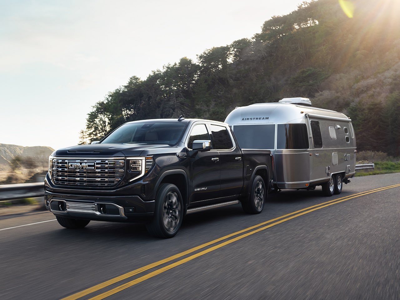 2026 GMC Sierra HD Towing an Airstream Travel Trailer on a Highway