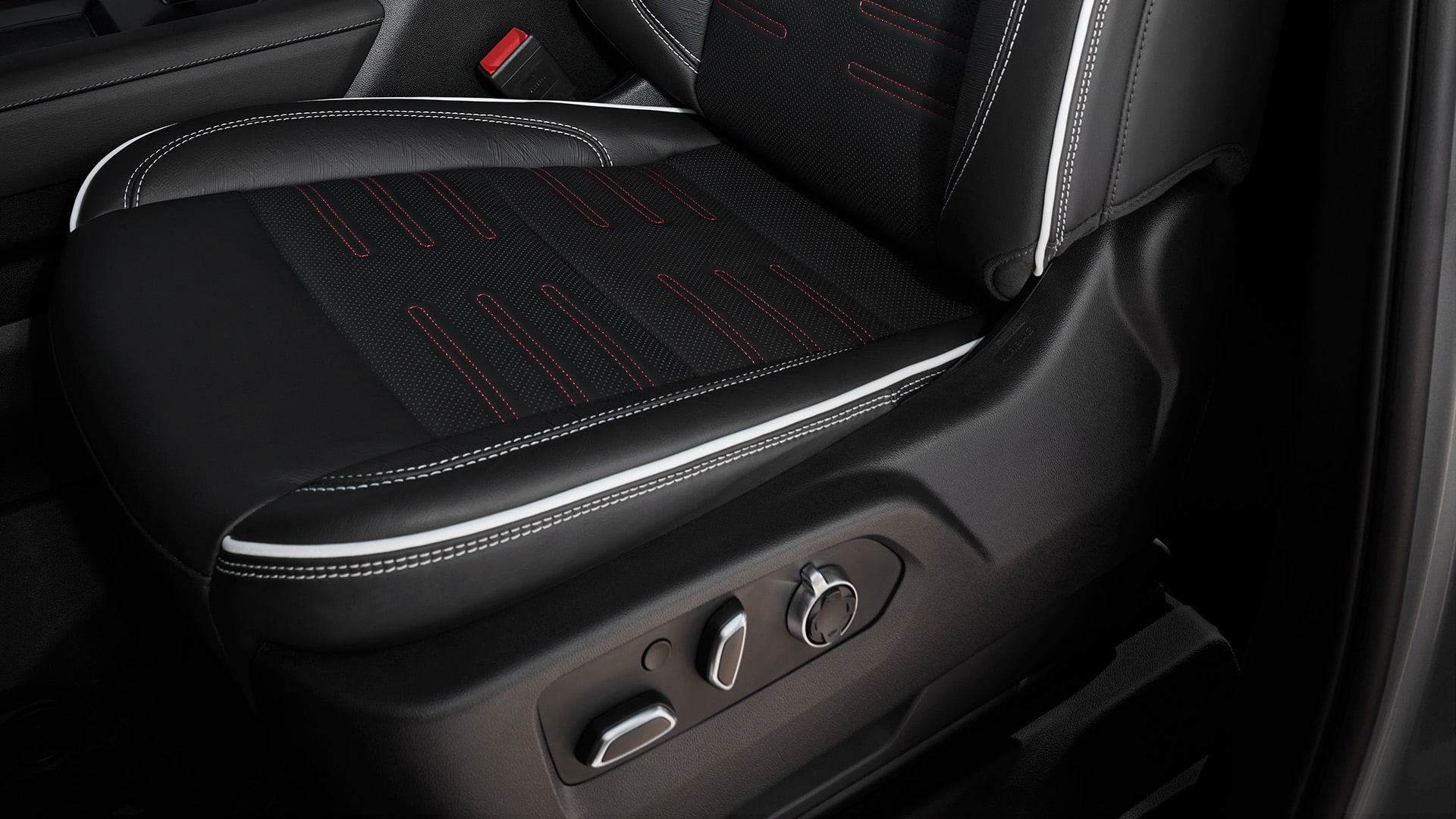 Close-up of a Black Leather Car Seat with Red Stitching and White Piping and Power Seat Controls