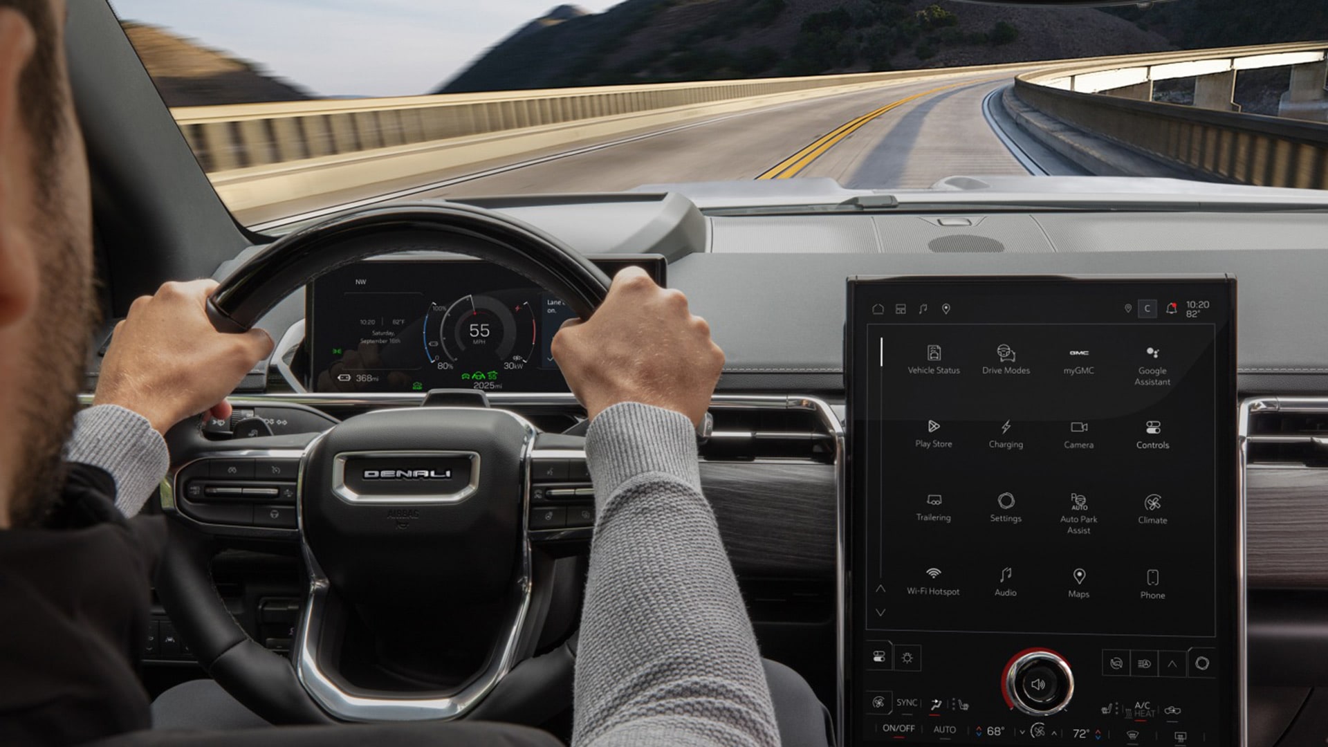 A Driver Keeps Hands on the Leather Steering Wheel of the Capable GMC Denali Vehicle