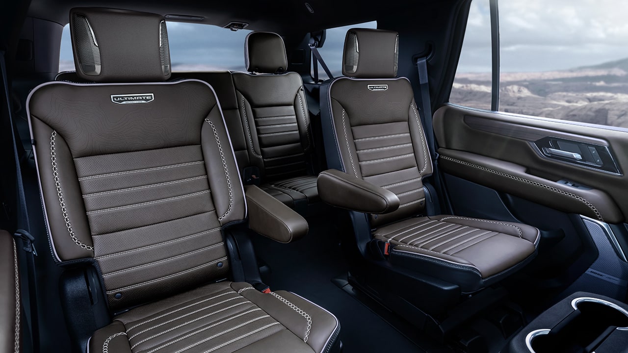 Brown Leather Interior Seats with White Stitching and Ultimate Branding in a GMC Vehicle with a Rocky Landscape Outside