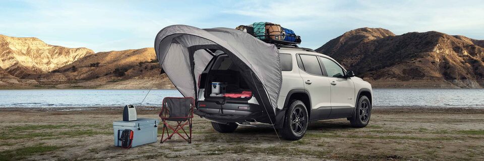 2021 GMC Yukon Denali driving on two-lane road through rugged terrain