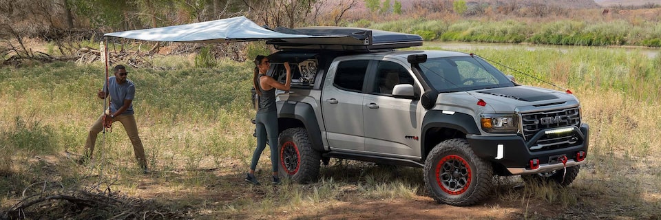 A Couple Setting up Their Rooftop Tent Accessory that is Attached to Their GMC Truck