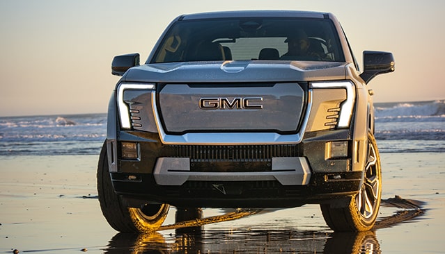 A GMC Sierra EV Parked in Front of a Beach.