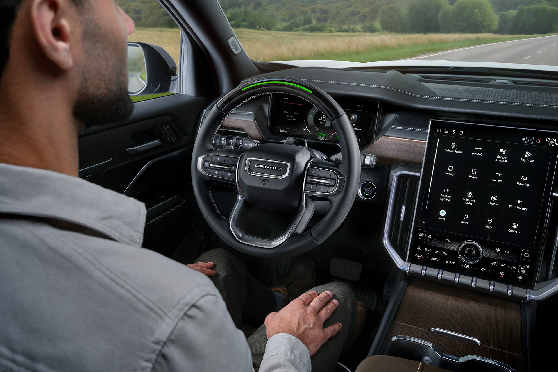 A Driver’s View of the GMC Denali Interior, Showing the Steering Wheel and Large Infotainment Screen with Controls