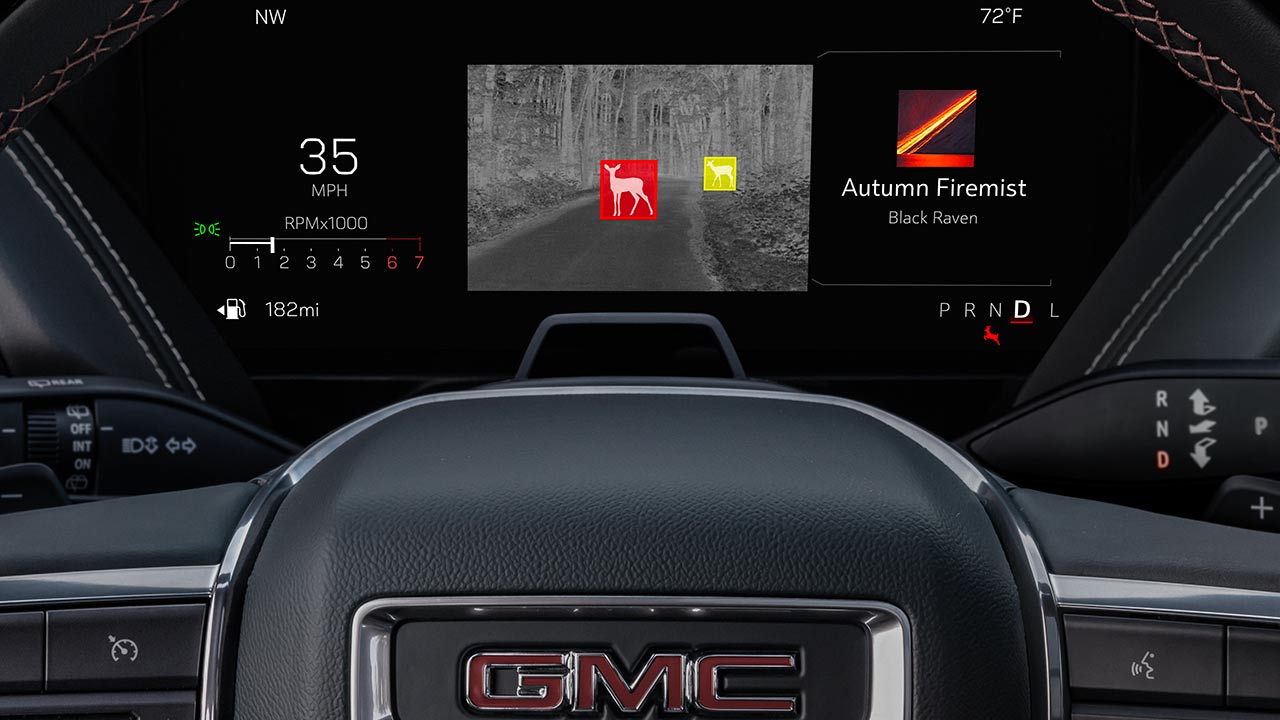 The Dashboard Display of a GMC Truck Shows a Night Vision View With Two Deer Highlighted in Red and Yellow Boxes on a Dark Road, Along With Vehicle Information and Infotainment