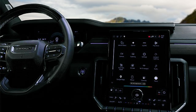 A Vehicle's Interior Showing the DENALI Steering Wheel and Infotainment Screen with myGMC and Google Gemini Apps