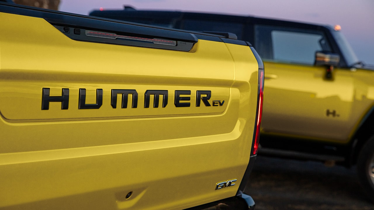 A Close-Up of the Black 'HUMMER EV' Badge on the Yellow Tailgate of a GMC Pickup Truck