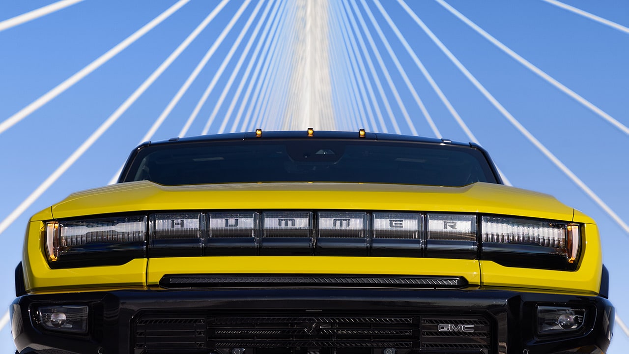 A Close-Up View of the Front Grille of a Yellow GMC HUMMER EV SUV on a Bridge