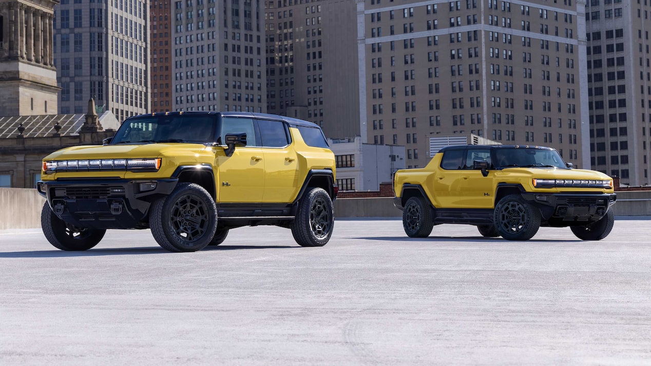 Two Yellow GMC HUMMER EV Vehicles, an SUV and a Pickup Truck, Parked in an Urban Setting