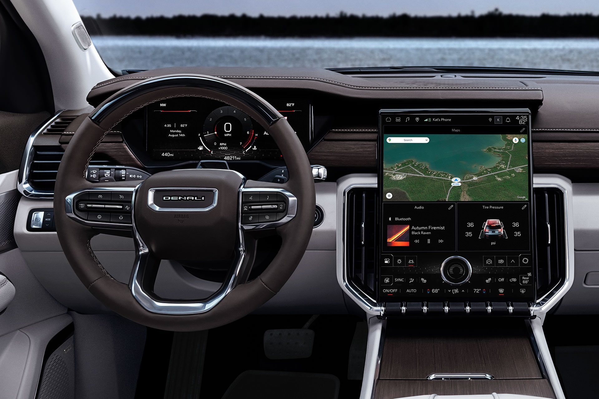 The Interior Dashboard of a GMC Denali Showing the Steering Wheel, Digital Gauge Cluster, and a Large Infotainment Screen with a Map