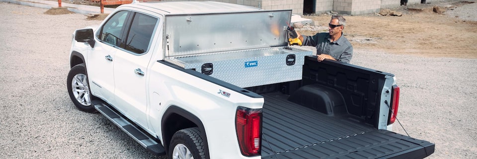A Man Pulling a Tool out of his Aluminum Truck Bed Tool Box on his GMC Truck