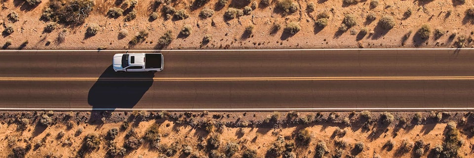 Overhead shot of GMC Sierra AT4 3L Duramax Diesel truck on desert road - wide view
