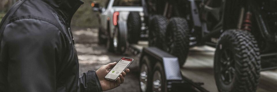 Man using his myGMC App to use the GMC Smart Trailer feature