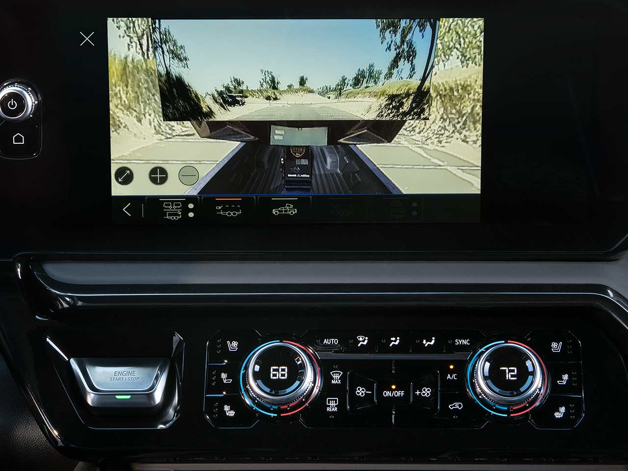 An Infotainment Screen in a GMC Truck Displays a Camera View of a Trailer Being Towed, With Climate Controls and Vehicle Functions Below