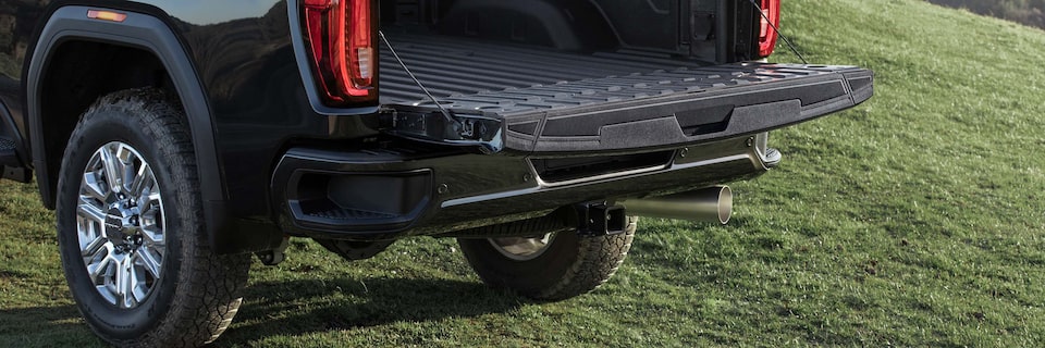 A Man Opening up the Rear Seats to Reveal Additional Cargo Space on a GMC Vehicle