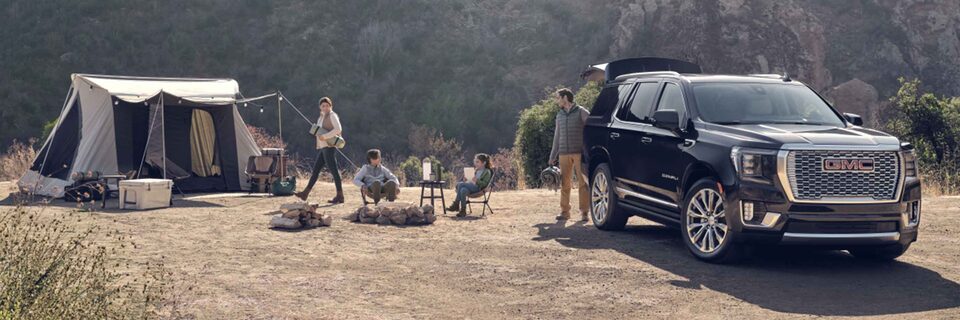Family camping with a GMC vehicle