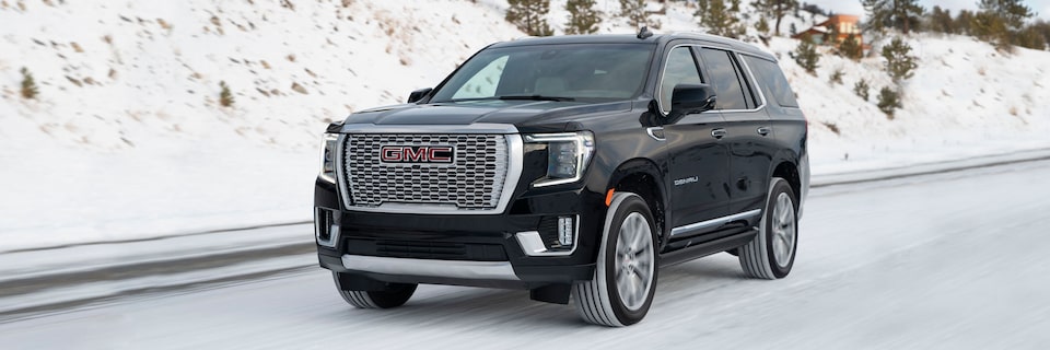The GMC Yukon Denali Driving Down a Snow Covered Road