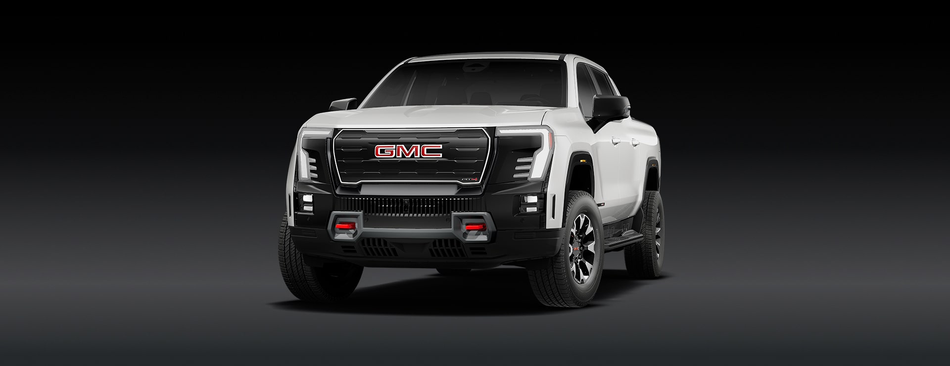 A White GMC Truck with Black Accents and GMC Logos on the Wheels