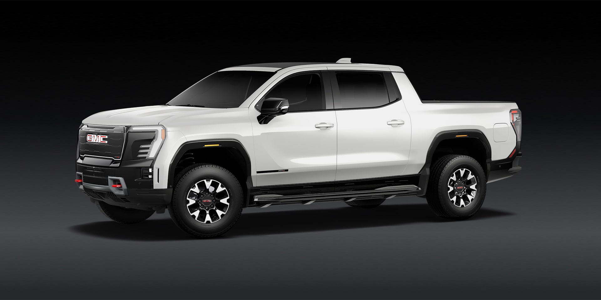 A White GMC Truck with Black Accents and GMC Logos on the Wheels