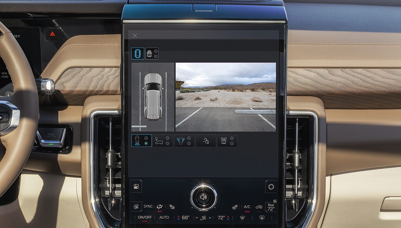 Vertical GMC Infotainment Screen Displaying HD Surround Vision with an Overhead View of a Truck and a Desert Parking Lot