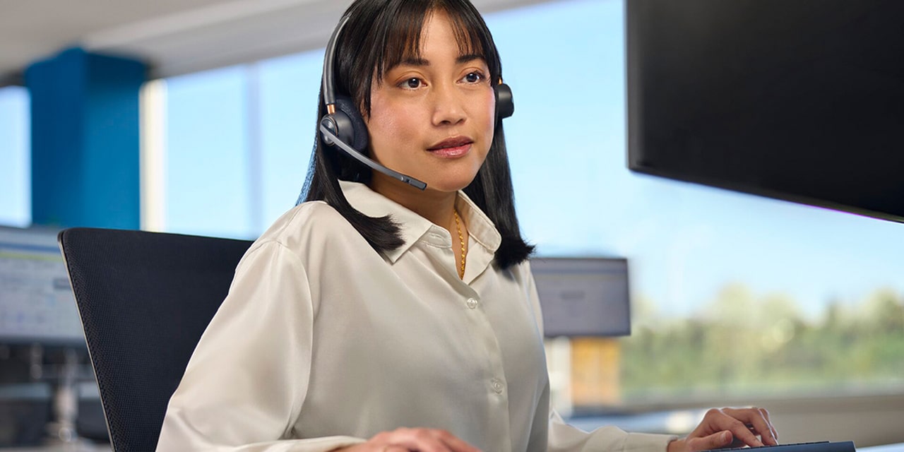 An OnStar Advisor Sitting at her Computer with a Headset on