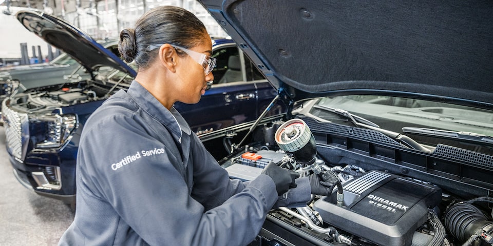 GMC Certified Service Technician Performing an Oil Change on a Vehicle