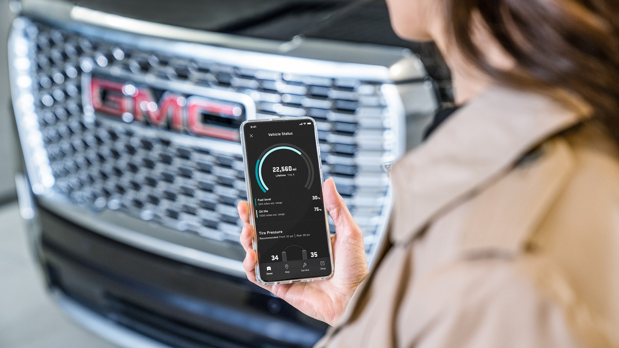 A Person Holding Their Smartphone While Using the myGMC Mobile App.