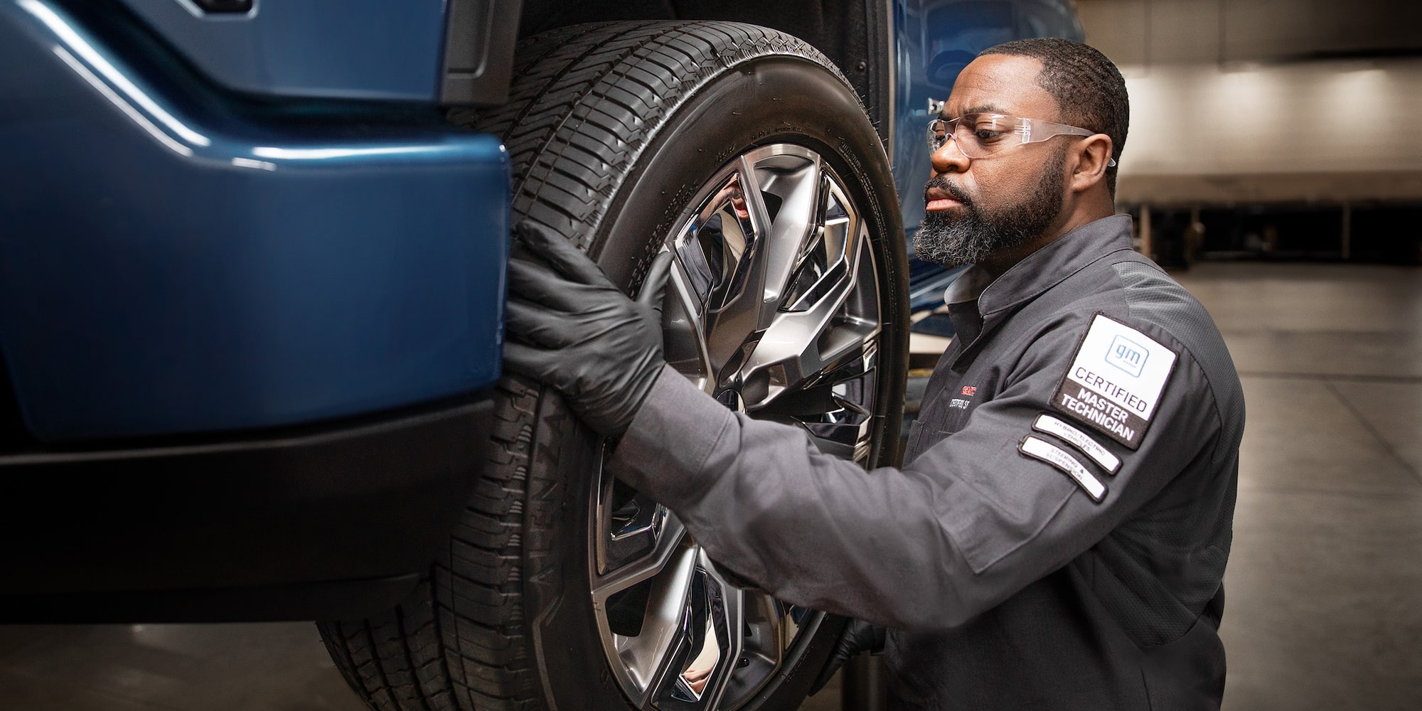 A Mechanic Wearing Safety Glasses Inspecting the Break of a Wheel inside a Vehicle