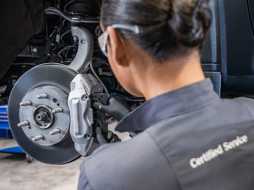 A Page with a Woman Seen Installing Break Pads on a Wheel of a Vehicle