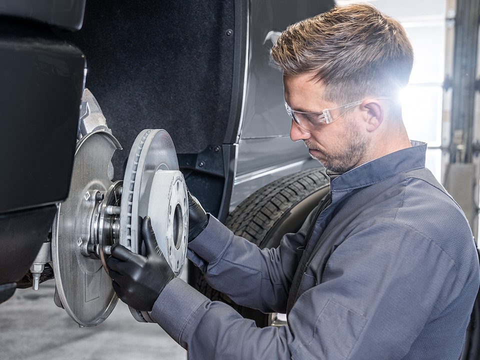 Side View of a Man Seen Installing a Break Rotor on a Vehicle