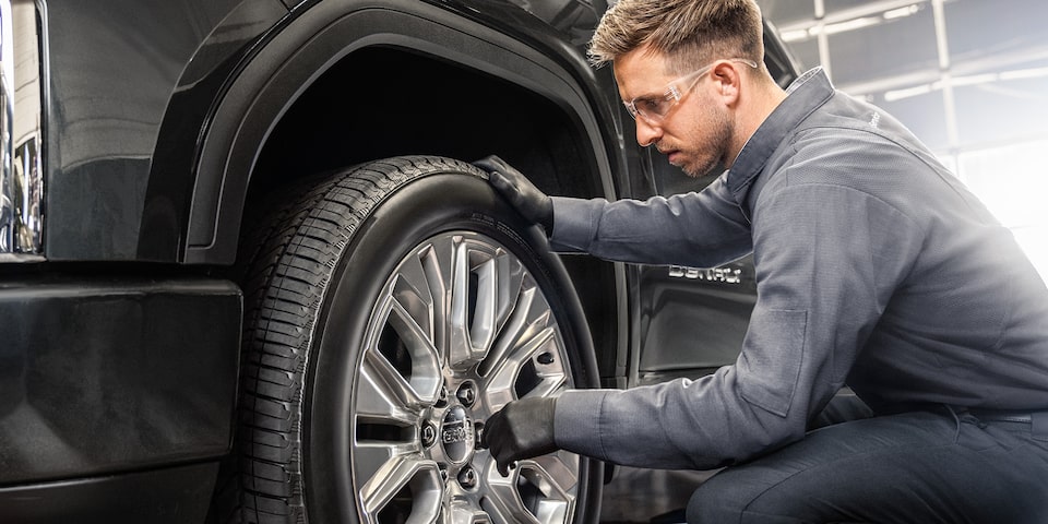 A Full Page View of a Deal for Tires Next to a Man Taking a Tire Off of a Vehicle