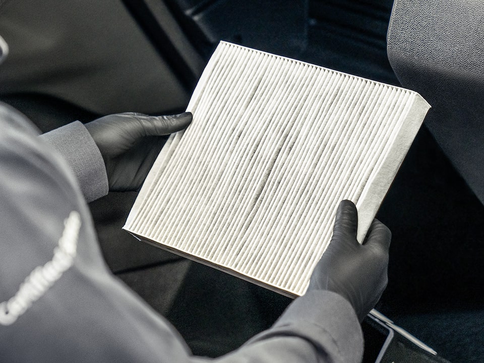 A Mechanic Is Replacing the Air Filter of a Vehicle