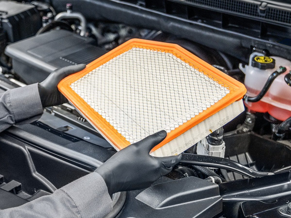 A Mechanic Is Replacing the Engine Filter of a Vehicle