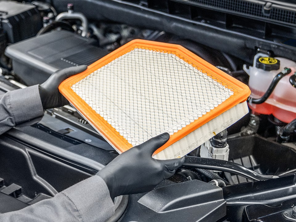 A Mechanic Is Replacing the Engine Filter of a Vehicle