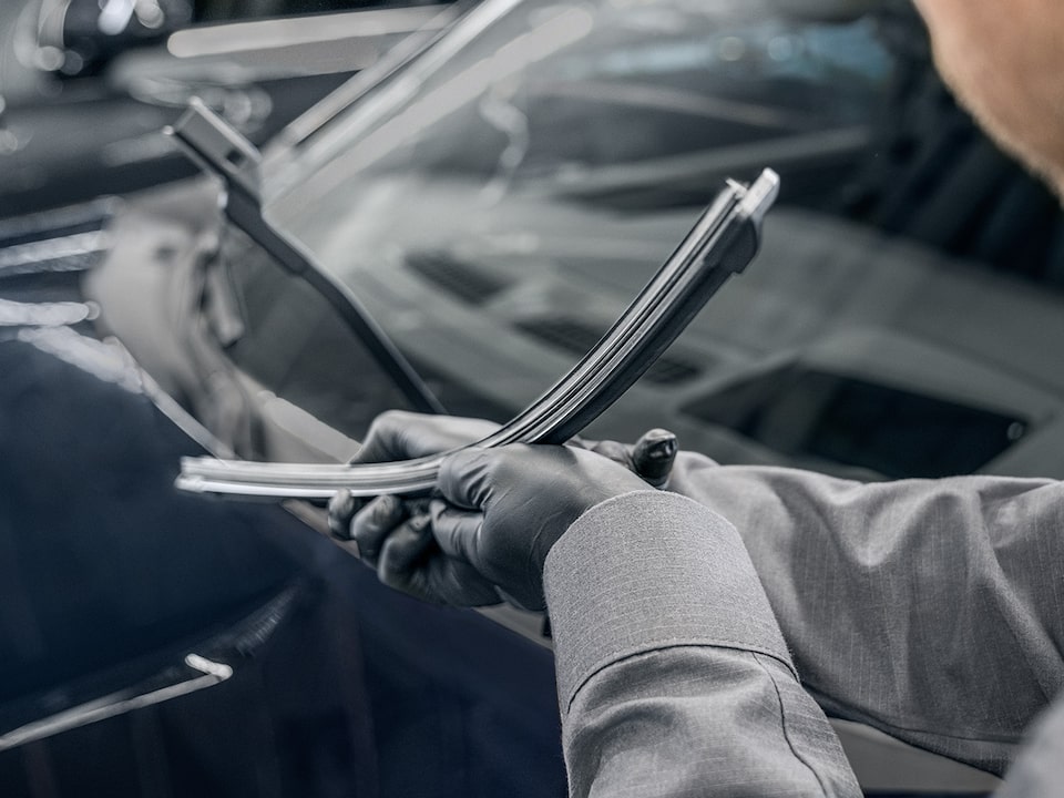 A Mechanic Is Seen Inspecting a Windshield Wiper